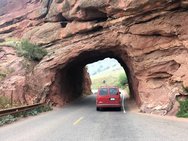 Van driving through rock tunnel