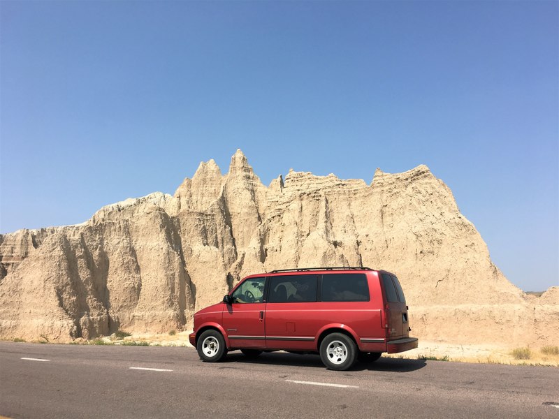 GMC Safari red van in Badlands landscape and rocks
